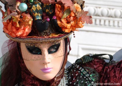 Grospla sur les yeux clairs d'une femme masquée à Venise