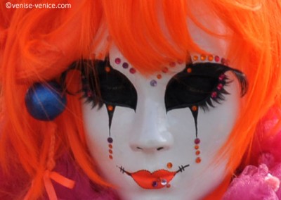 Perruqye et lèvres couleur orange Fluo sur le masque d'une femme